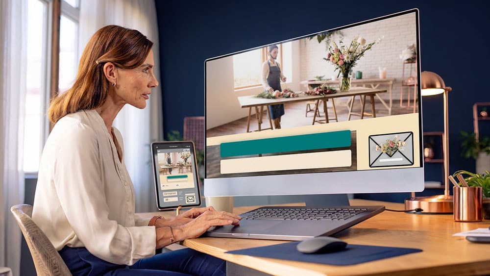 Newsletter designer editing an email with a visual campaign layout and mobile preview